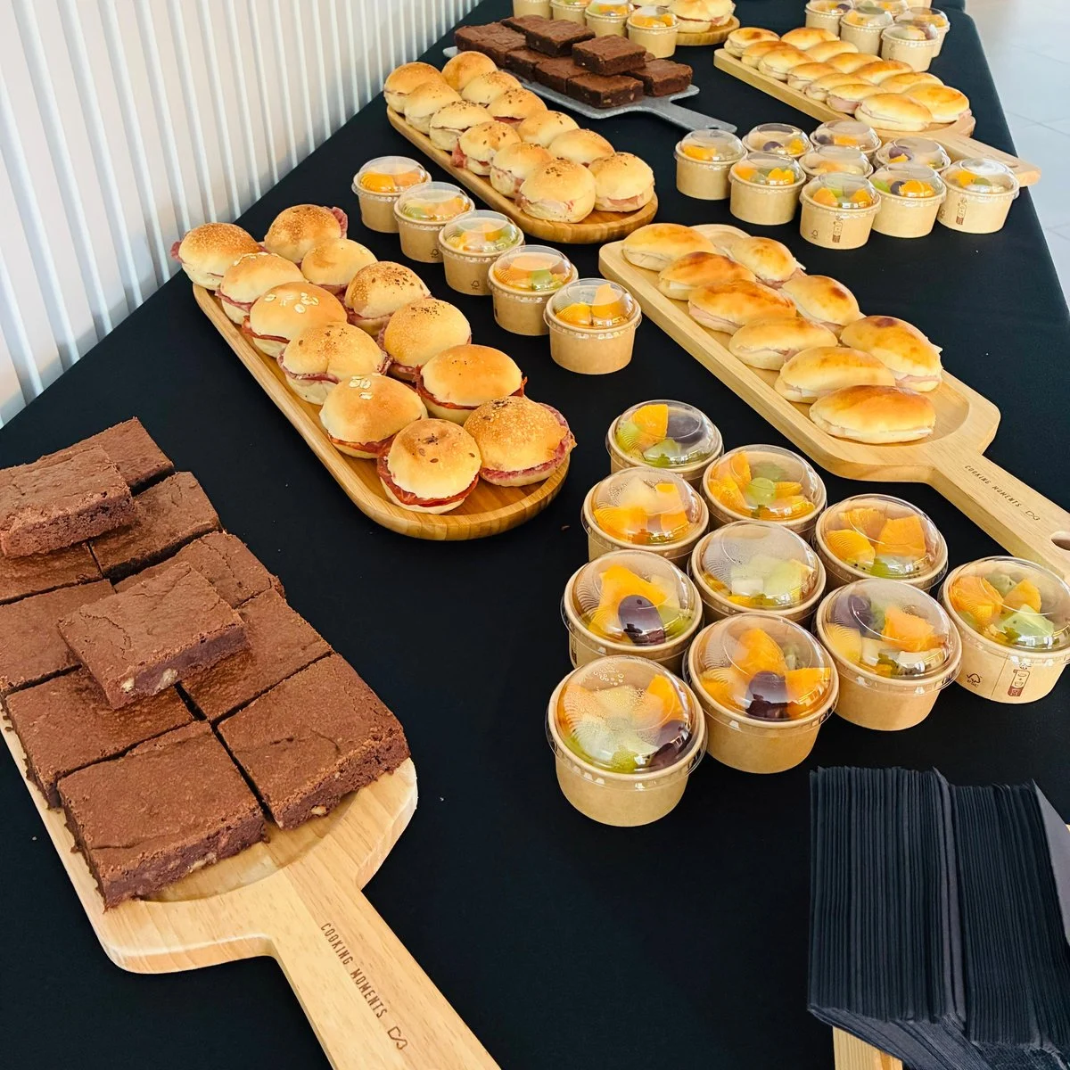 Mesa de coffee break con brownies, mini bocadillos y mini macedonias de frutas